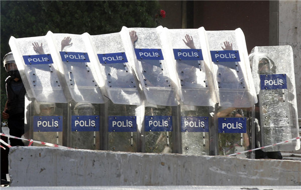 Riot police behind shields fire tear gas as they clash with anti-government protesters at Taksim square in central Istanbul June 1, 2013. [Agencies]