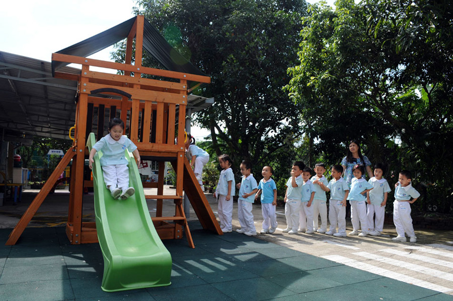 5月28日，在香港上水培幼幼稚园，孩子们在老师的带领下玩滑梯。他们被称为“跨境学童”，即生活在深圳，在香港读书，拥有香港居民身份的孩子。香港教育局提供的数据显示，2012至2013年度，1.6余万名跨境学童在港就读。[新华社 赵宇思 摄]