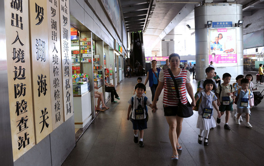 上幼稚园下午班的跨境儿童在保姆的带领下过关去香港上学。跨境学童的源起要追溯到上世纪80年代，两地来往日趋频繁，越来越多的港人跨境工作、生活，其子女在港就读，于是出现了跨境上学的现象。[新华社 赵宇思 摄]