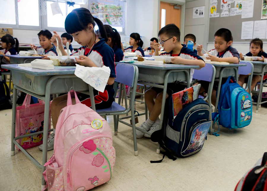 在香港上水惠州公立学校，一年级小学生在吃午饭。2009年内地孕妇在港所生婴儿3.7万人，占全港新生儿的45%。这使得居于内地而拥有香港身份的儿童数目不断增加。1990年跨境学童只有几百人，2009年增加到8000多人。[新华社 赵宇思 摄]