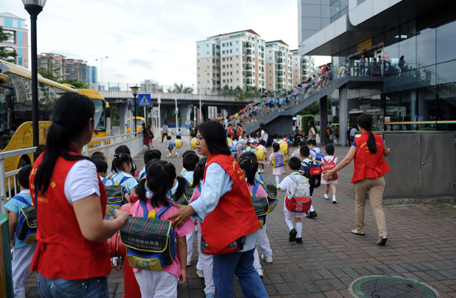 5月29日早上7点多，在深圳福田口岸，跨境儿童在保姆的护送下准备过关去香港上学。[新华社 赵宇思 摄]