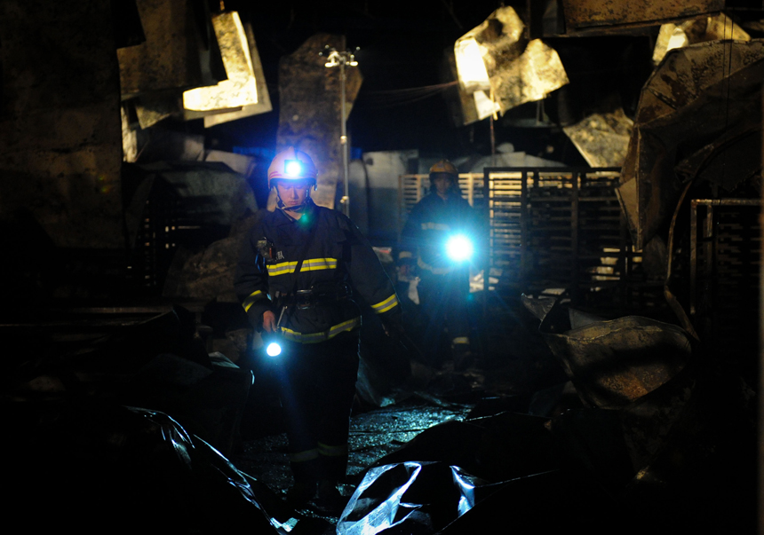 Fire fighters are pictured next to a burnt poultry slaughterhouse owned by the Jilin Baoyuanfeng Poultry Company in Mishazi Township of Dehui City in northeast China&apos;s Jilin Province, June 3, 2013. The death toll from the fire has risen to 119 as of 8 p.m. on Monday. Search and rescue work is under way. [Photo/Xinhua]