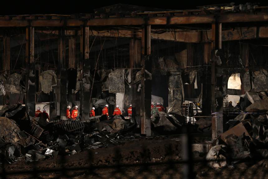 Fire fighters are pictured next to a burnt poultry slaughterhouse owned by the Jilin Baoyuanfeng Poultry Company in Mishazi Township of Dehui City in northeast China&apos;s Jilin Province, June 3, 2013. The death toll from the fire has risen to 119 as of 8 p.m. on Monday. Search and rescue work is under way. [Photo/Xinhua]