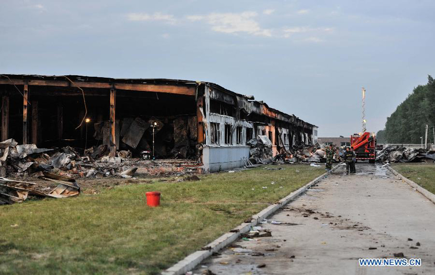 Fire fighters are pictured next to a burnt poultry slaughterhouse owned by the Jilin Baoyuanfeng Poultry Company in Mishazi Township of Dehui City in northeast China&apos;s Jilin Province, June 3, 2013. The death toll from the fire has risen to 119 as of 8 p.m. on Monday. Search and rescue work is under way.