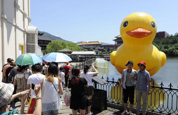 Visitor to Hengdian World Studios in Dongyang, Zhejiang province, take photos of an inflatable rubber duck. [Photo/Asianewsphoto]