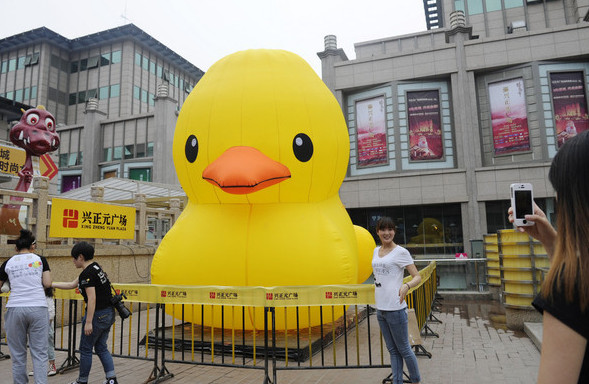 Visitors to Xi'an, take photos of an inflatable rubber duck. 