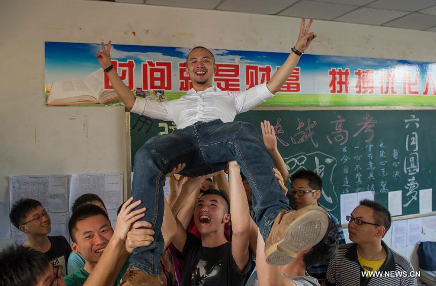 Students raise their teacher He Xueyi to express gratitudes on the occasion of their graduation at the Yucai Middle School in Chongqing, southwest China, June 4, 2013. Three days later, the high school graduates will take part in the national college entrance exam, which is set for June 7 and 8.