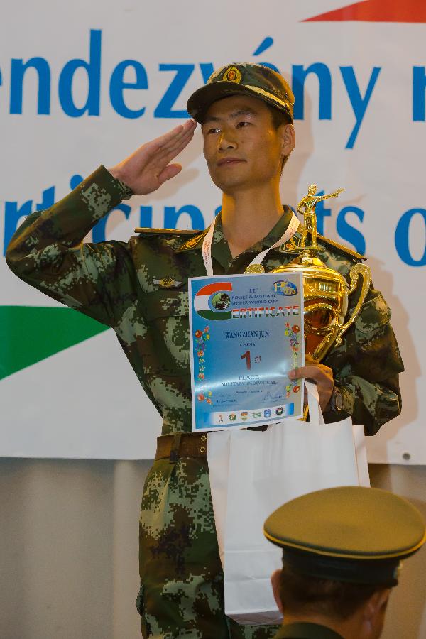 Wang Zhanjun of China poses with his trophy during the awarding ceremony at the 12th Police and Military Sniper World Cup in Budapest, Hungary, on June 4, 2013. Wang won the gold medal of Individual Military competition of the event. 