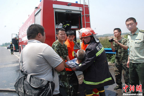 Firefighters remove a wounded person from the scene of a series of car accidents in the Zhumadian section of Beijing-Hong Kong-Macao Expressway in central China's Henan province on Tuesday June 4, 2013. [Photo/China News Service]