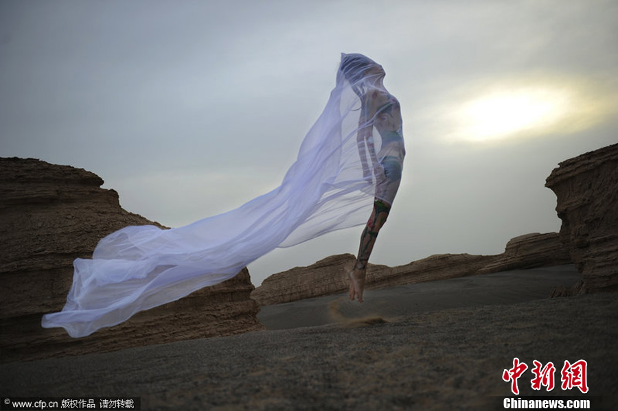 A female body-paint model poses on the ground outside the Mogao Grottoes in Jiuquan City, in northwestern China’s Gansu Province. The models are volunteers for a campaign to protect the Mogao Grottoes. The campaign, which was initiated by the non-governmental organization Idea Beautify China, also aims to raise awareness about preserving historic and cultural heritage elsewhere.