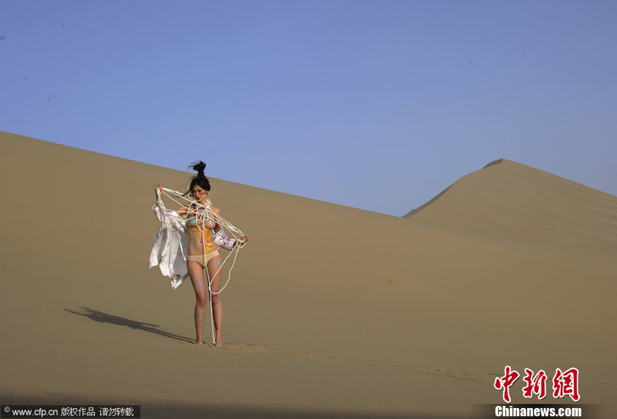  A female body-paint model poses on a desert in Jiuquan City, in northwestern China’s Gansu Province. The models are volunteers for a campaign to protect the Mogao Grottoes. The campaign, which was initiated by the non-governmental organization Idea Beautify China, also aims to raise awareness about preserving historic and cultural heritage elsewhere. 