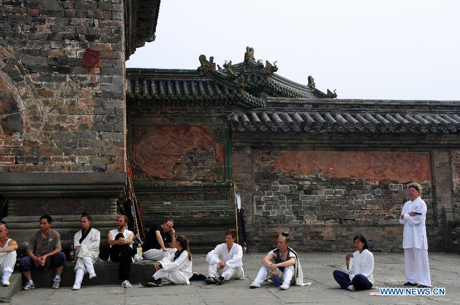 Foreign learners have a break while practising Chinese martial arts at the Yuxu Palace on Wudang Mountain, known as a traditional center for the teaching and practice of martial arts, in central China's Hubei Province, June 5, 2013. (Xinhua/Hao Tongqian) 