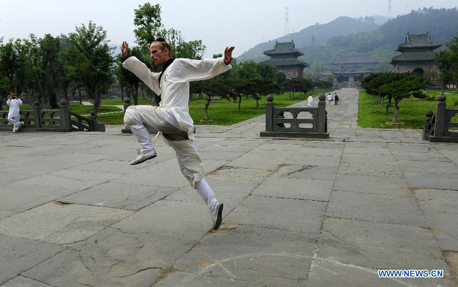 A foreign learner practises Chinese martial arts movements at the Yuxu Palace on Wudang Mountain, known as a traditional center for the teaching and practice of martial arts, in central China's Hubei Province, June 5, 2013. (Xinhua/Hao Tongqian)
