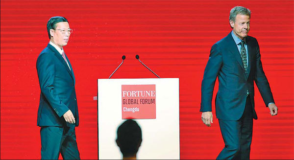 Vice-Premier Zhang Gaoli, accompanied by Time Warner Inc Chief Executive Jeff Bewkes, walks to the podium to deliver his keynote speech at the opening ceremony of the Fortune Global Forum in Chengdu, Sichuan province, on Thursday.[China Daily]