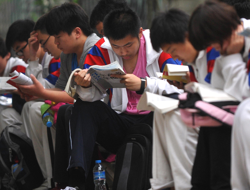 Students wait outside an examination site in Beijing on June 7. Some 9.12 million applicants are expected to sit this year&apos;s college entrance exam, down from 9.15 million in 2012, a spokeswoman for the Ministry of Education (MOE) said on Wednesday. [Photo/Xinhua] 