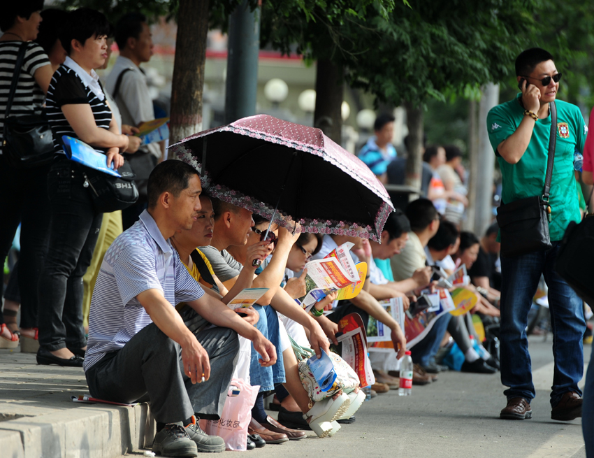 Parents wait outside an examination site in Lanzhou, Gansu Province, on June 7. Some 9.12 million applicants are expected to sit this year&apos;s college entrance exam, down from 9.15 million in 2012, a spokeswoman for the Ministry of Education (MOE) said on Wednesday. [Photo/Xinhua] 