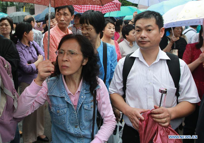 Parents watch their children entering the exam site to take the national college entrance exam in Shanghai, east China, June 7, 2013. Some 9.12 million applicants are expected to sit this year&apos;s college entrance exam.