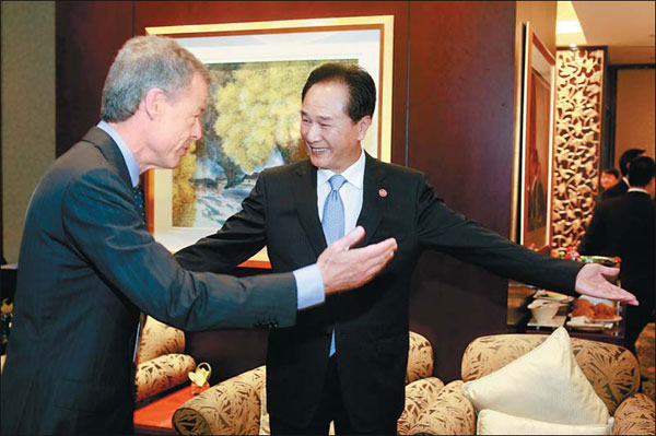 Cai Mingzhao (right), minister of the State Council Information Office, greets Time Warner Chairman and CEO Jeff Bewkes on the sidelines of the Fortune Global Forum in Chengdu, Sichuan province, on Friday. [China Daily]