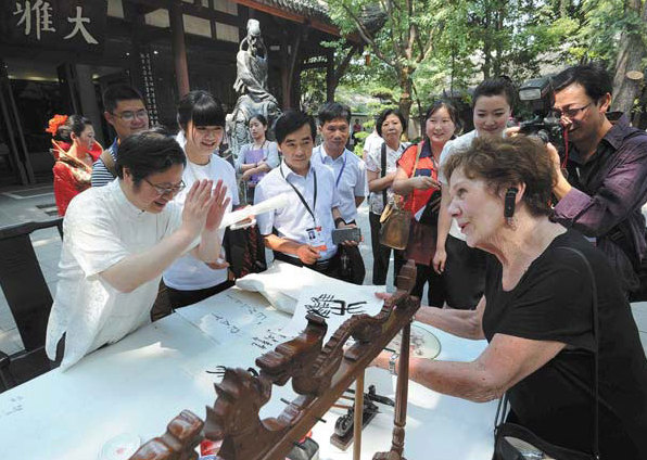 Local calligrapher Su Jiongshu composes a piece as a gift for an American guest who is the wife of a forum participant. [China Daily]