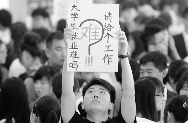 A graduate holds a paper which says 'Is it difficult to find a job for graduates? Yes. Please give me a job', at a recruitment fair for young people in Bozhou, Anhui province. This year was described as the 'toughest year' for college graduates. [China Daily]