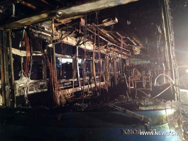 Photo taken by mobile phone on June 7, 2013 shows the debris of a bus on an elevated track in Xiamen, southeast China&apos;s Fujian Province. At least 47 people died and more than 30 others were injured after the bus in the city&apos;s BRT (bus rapid transit) service burst into flames at about 6:30 p.m. on Friday. [Photo/Xinhua]