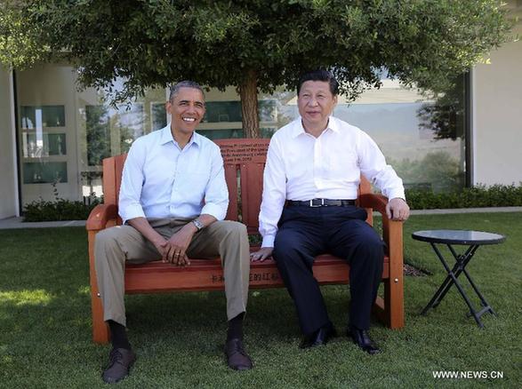 U.S. President Barack Obama (L) presents Chinese President Xi Jinping with a bench made of California redwood while they take a joint walk before heading into their second meeting, at the Annenberg Retreat, California, the United States, June 8, 2013. Chinese President Xi Jinping and U.S. President Barack Obama held the second meeting on Saturday to exchange views on economic ties. [Lan Hongguang/Xinhua]
