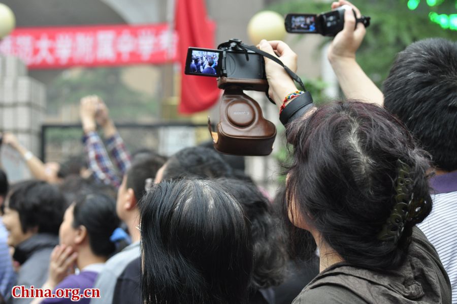 Family members of students anxiously wait outside the exam site at the High School Attached to Capital Normal University on Saturday afternoon. China&apos;s 2013 colleage entrance examination or gaokao ends on Saturday. A total of 72, 736 students in Beijing have registered to sit this &apos;big test.&apos; [Photo / Gong Yingchun]