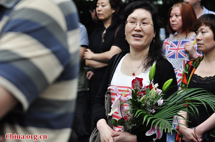 Family members of students anxiously wait outside the exam site at the High School Attached to Capital Normal University on Saturday afternoon. China&apos;s 2013 colleage entrance examination or gaokao ends on Saturday. A total of 72, 736 students in Beijing have registered to sit this &apos;big test.&apos; [Photo / Gong Yingchun]