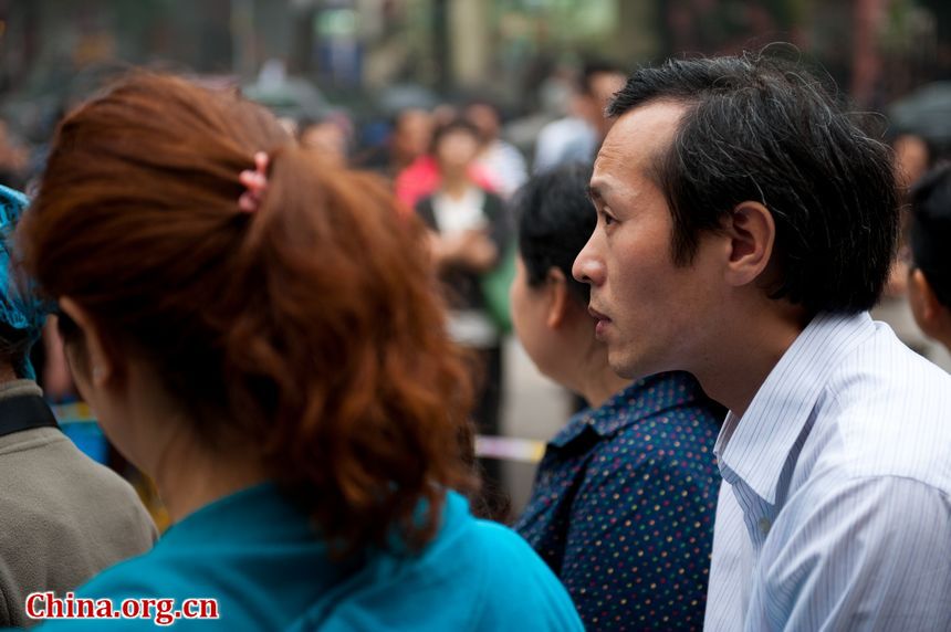 Family members of students anxiously wait outside the exam site at the High School Attached to Capital Normal University on Saturday afternoon. China&apos;s 2013 colleage entrance examination or gaokao ends on Saturday. A total of 72, 736 students in Beijing have registered to sit this &apos;big test.&apos; [Photo / Gong Yingchun]