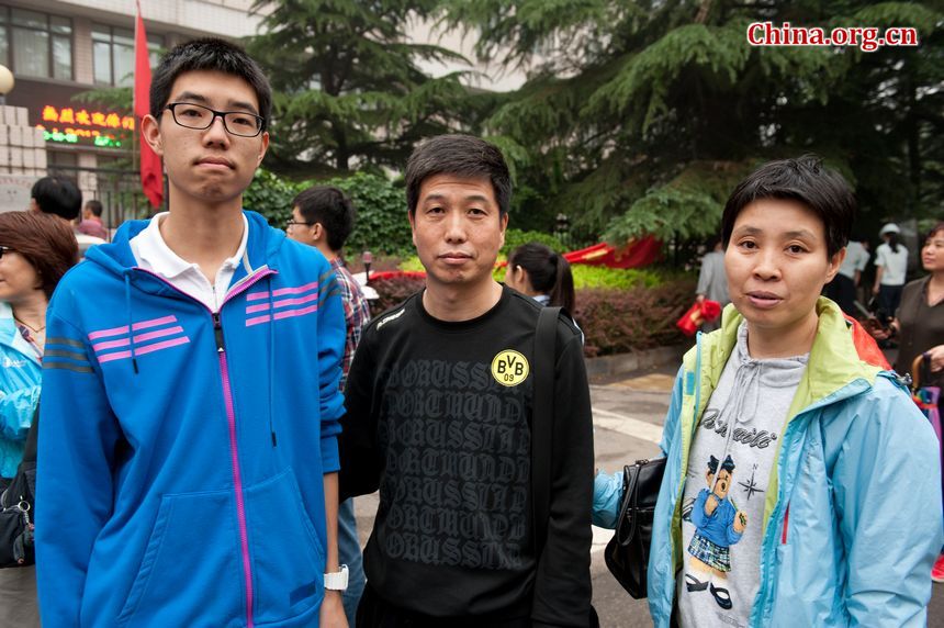 A student and his parents beam at the camera after the boy finishes the college examination on Saturday, June 8, 2013 in Beijing. The student says he wishes to go to Tianjin University. [Photo / Chen Boyuan]