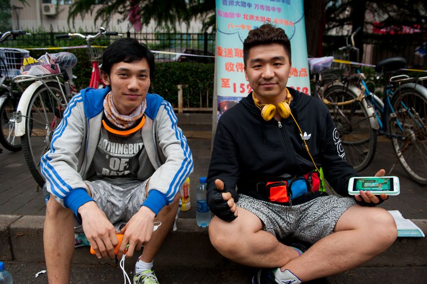 Cyclist volunteers who provide free assistance to test takers who forget to bring IDs. They promise to bring back students&apos; IDs within 9+30 minutes from any part of the urban area in Beijing and are proud of their &apos;faster-than-automobile&apos; service [Photo / Chen Boyuan]