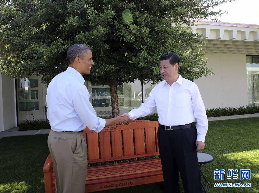 U.S. President Barack Obama (L) presents Chinese President Xi Jinping with a bench made of California redwood while they take a joint walk before heading into their second meeting, at the Annenberg Retreat, California, the United States, June 8, 2013. Chinese President Xi Jinping and U.S. President Barack Obama held the second meeting here on Saturday to exchange views on economic ties