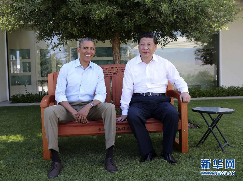 U.S. President Barack Obama (L) presents Chinese President Xi Jinping with a bench made of California redwood while they take a joint walk before heading into their second meeting, at the Annenberg Retreat, California, the United States, June 8, 2013. Chinese President Xi Jinping and U.S. President Barack Obama held the second meeting here on Saturday to exchange views on economic ties. 