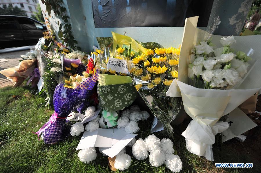 Flowers are laid to mourn for the victims in front of a pier of the elevated bus lane where a bus fire took place on Friday, in Xiamen, southeast China&apos;s Fujian Province, June 8, 2013. The bus fire has claimed 47 lives and hospitalized 34 passgengers.