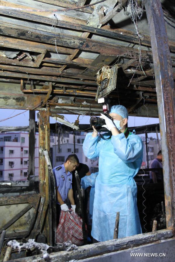 Investigators work inside the debris of a burned bus in Xiamen, southeast China&apos;s Fujian Province, early June 8, 2013. The bus fire happening in Xiamen on Friday evening has claimed 47 lives and hospitalized 34 passgengers. An old man who allegedly set fire to the crowded bus to &apos;vent personal grievances&apos; had died in the blaze, local authorities said Saturday. Chen Shuizong, born in 1954 and a native of Xiamen, was identified as the arsonist of the fire.