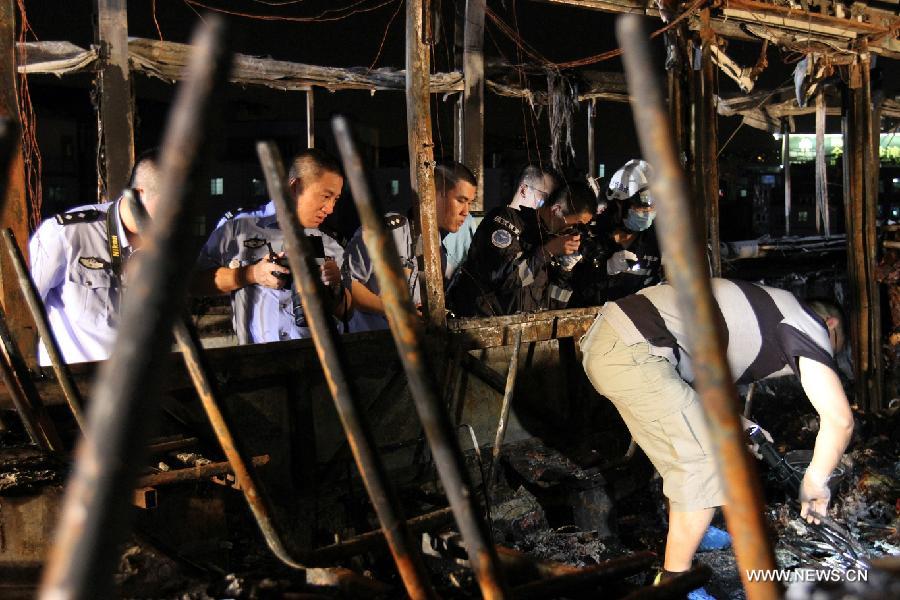 Investigators work inside the debris of a burned bus in Xiamen, southeast China&apos;s Fujian Province, early June 8, 2013. The bus fire happening in Xiamen on Friday evening has claimed 47 lives and hospitalized 34 passgengers. An old man who allegedly set fire to the crowded bus to &apos;vent personal grievances&apos; had died in the blaze, local authorities said Saturday. Chen Shuizong, born in 1954 and a native of Xiamen, was identified as the arsonist of the fire.