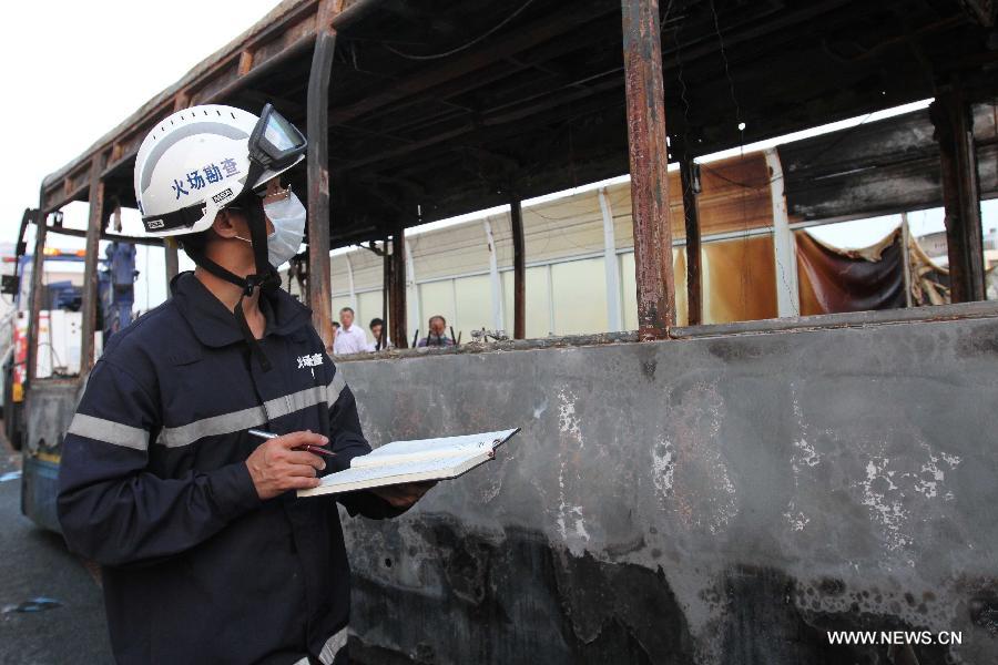 An investigator works outside the debris of a burned bus in Xiamen, southeast China&apos;s Fujian Province, early June 8, 2013. The bus fire happening in Xiamen on Friday evening has claimed 47 lives and hospitalized 34 passgengers. An old man who allegedly set fire to the crowded bus to &apos;vent personal grievances&apos; had died in the blaze, local authorities said Saturday. Chen Shuizong, born in 1954 and a native of Xiamen, was identified as the arsonist of the fire. 