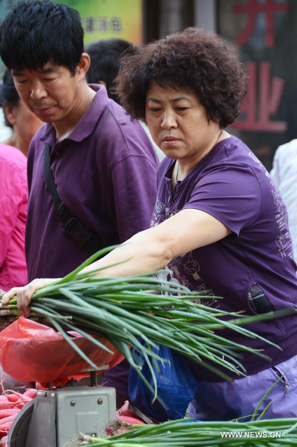 A woman chooses vegetables in a market in Changchun, capital of northeast China&apos;s Jilin Province, June 9, 2013. China&apos;s consumer price index (CPI), a main gauge of inflation, grew 2.1 percent year on year in May, down from 2.4 percent in April, the National Bureau of Statistics said on Sunday.