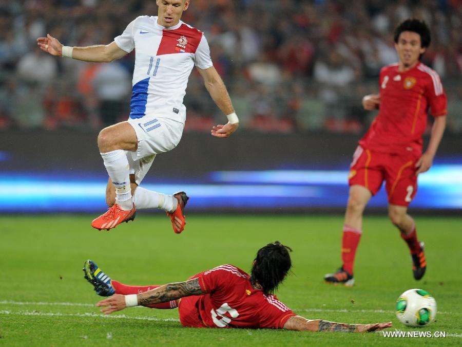 Arjen Robben (Top) of the Netherlands vies with China&apos;s Zhang Linpeng during their international friendly soccer match at the Workers Stadium in Beijing, capital of China, June 11, 2013. (Xinhua/Gong Lei) 