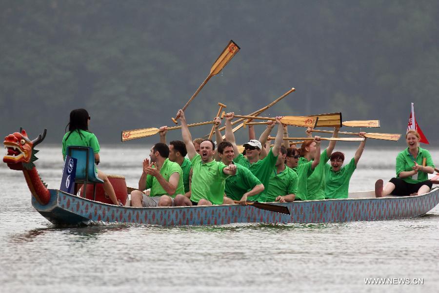 Participants cheer while finishing a boat race held to mark the annual Dragon Boat Festival on the Mochou Lake, Nanjing, east China&apos;s Jiangsu Province, June 10, 2013. This year&apos;s Dragon Boat Festival falls on June 12. (Xinhua/Han Hua)