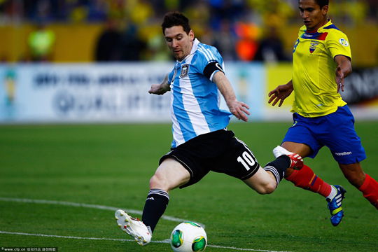 Fernado Saritama (R) of Ecuador vies for the ball with Lionel Messi (C) of Argentina during a soccer match for the qualifying round to Brazil 2014 World Cup at the Atahualpa stadium in Quito, Ecuador, on 11 June 2013.