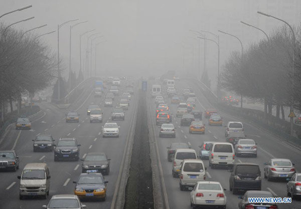 Vehicles run on the fog-shrouded street in Beijing, capital of China, Jan. 30, 2013. [Xinhua]