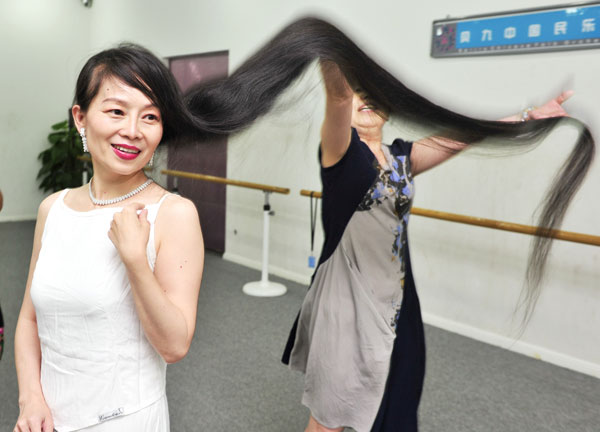 Li Menglu, 49, shows her long hair in Xi'an, Northwest China's Shaanxi province, June 17, 2013. Li's hair is 1.7 meters long, and she has kept her hair for 35 years. She developed the hobby because her parents thought it 'soft and delicate' for a woman to keep long hair. [Photo by Yuan Jingzhi/Asianewsphoto] 