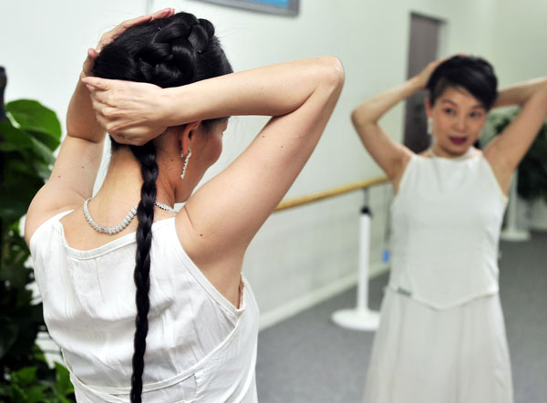 Li Menglu, 49, shows her long hair in Xi'an, Northwest China's Shaanxi province, June 17, 2013. Li's hair is 1.7 meters long, and she has kept her hair for 35 years. She developed the hobby because her parents thought it 'soft and delicate' for a woman to keep long hair. [Photo by Yuan Jingzhi/Asianewsphoto] 