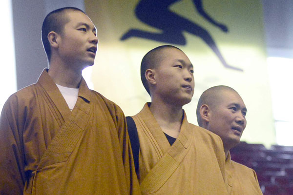 Monks from the temple cheer for their team during a national badminton tournament. [Photo/China Daily]