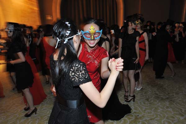 Two masked girls dance together at a prom held at the Hotel Novotel Wuhan Xinhua in Wuhan, Hubei province, on June 17, 2013. [Photo/Asianewsphoto] 