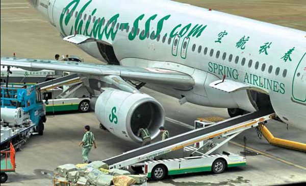 A Spring Airlines' plane at Pudong International Airport, Shanghai. During the poor market in 2012, Spring Airlines maintained a seat-kilometer utilization of up to 95 percent, in stark contrast with the industry average of between 79 and 80 percent. [China Daily]