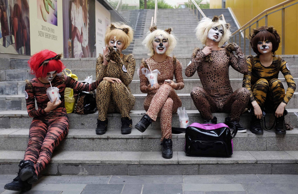 Volunteers in animal costumes wait to perform in an event to promote a love for dogs, in Beijing's Sanlitun area, on June 20, 2013. Dog lovers and animal rights activists have called for the cancellation of an annual dog meat festival scheduled to take place on Friday in Yulin, Guangxi Zhuang autonomous region, voicing concerns over animal cruelty and food safety. [Photo/China Daily via Agencies]