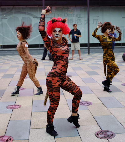 Volunteers dressed in animal costumes perform during an event promoting a love for dogs, in Beijing's Sanlitun area, on June 20, 2013.[Photo/China Daily via Agencies]