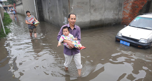 Local residents cope with heavy rainfall as water covered the streets in Chengdu, Southwest China's Sichuan province on June 19, 2013. Chengdu suffered a heavy rainstorm on Wednesday night which lasted until Thursday morning and water flooded many roads and fields in the city. No fatalities have been reported so far. [Photo/Xinhua] 
